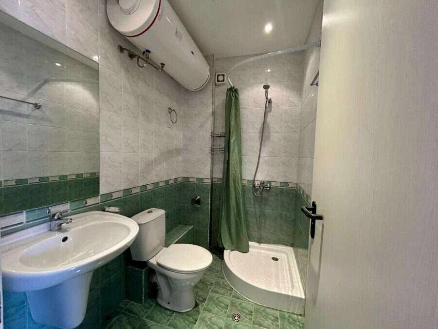 Bright, clean bathroom with shower, toilet, and sink in a seaside property.