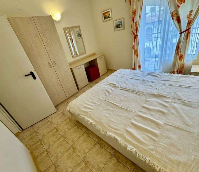 Bright bedroom with large bed and balcony view.