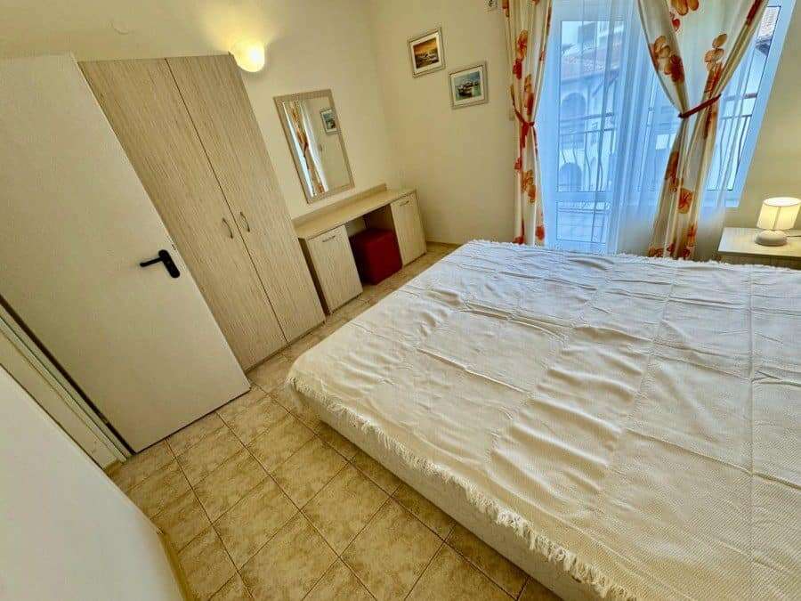 Bright bedroom with large bed and balcony view.