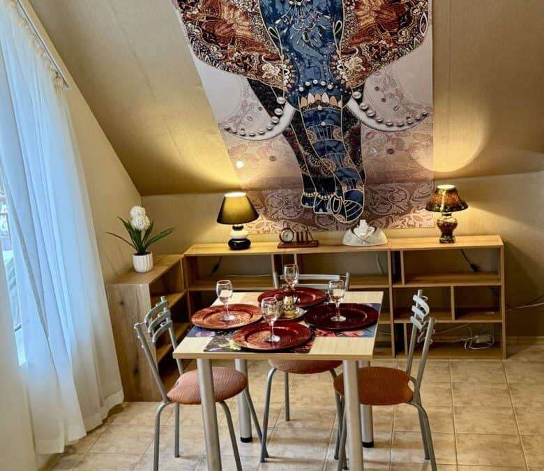 Modern dining space with a wooden table and four chairs, decorated with elegant tableware, featuring.