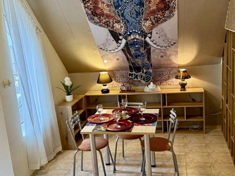 Modern dining space with a wooden table and four chairs, decorated with elegant tableware, featuring.