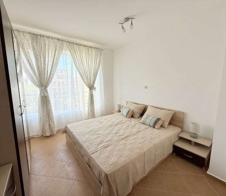 Bright apartment with spacious living area and large windows with curtains.