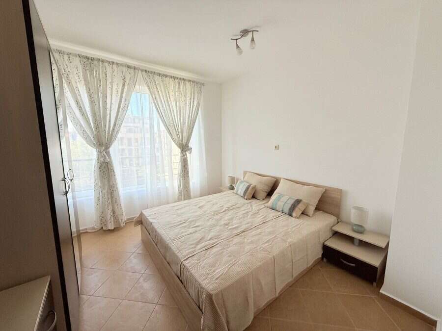 Bright apartment with spacious living area and large windows with curtains.