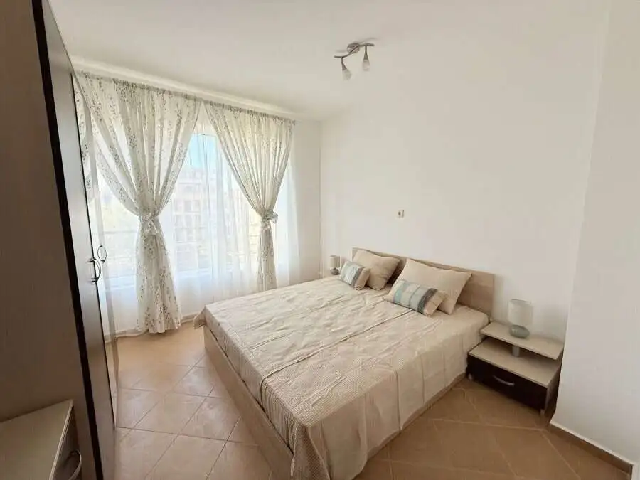 Bright apartment with spacious living area and large windows with curtains.