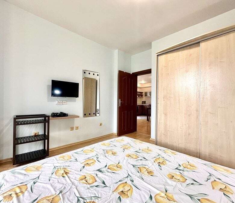 Apartment interior with a bed, TV, and wardrobe in Sveti Vlas.
