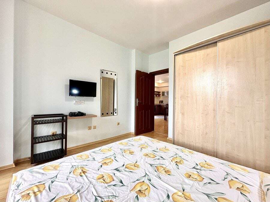 Apartment interior with a bed, TV, and wardrobe in Sveti Vlas.