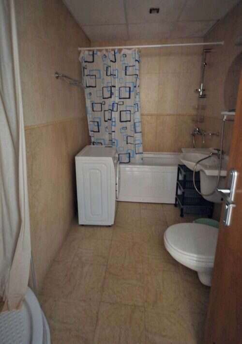 Bathroom with bathtub, toilet, and washing machine in a 1-bed apartment in Palazzo, Sunny Beach.