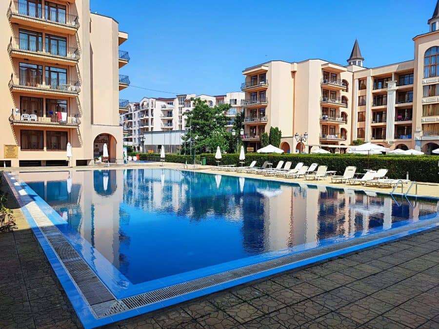 Pool view of a luxurious apartment complex in Sunny Beach with a large swimming pool and surrounding.