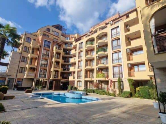 Pool view of a 1-bedroom apartment in Harmony Suites, surrounded by lush greenery and modern ameniti.