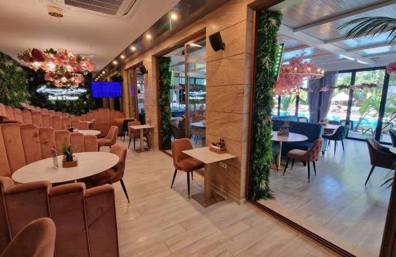 Indoor lounge with comfortable seating and large windows overlooking the pool area.
