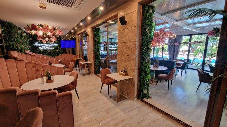 Indoor lounge with comfortable seating and large windows overlooking the pool area.