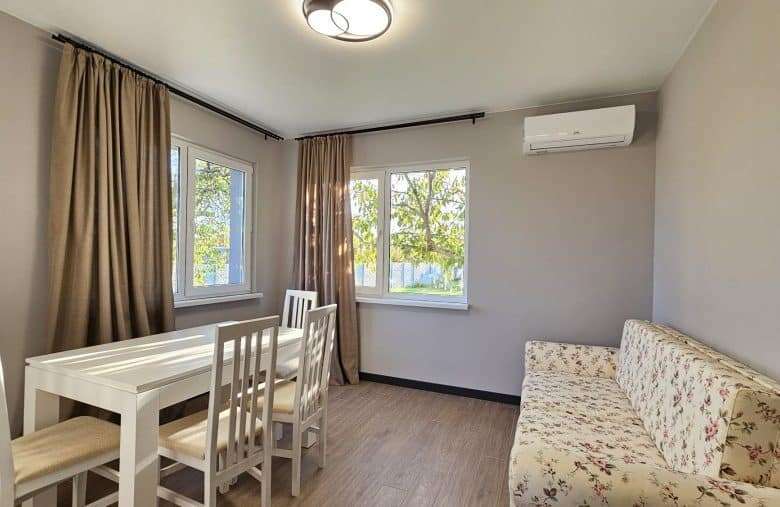Bright interior with large windows and comfortable furnishings.