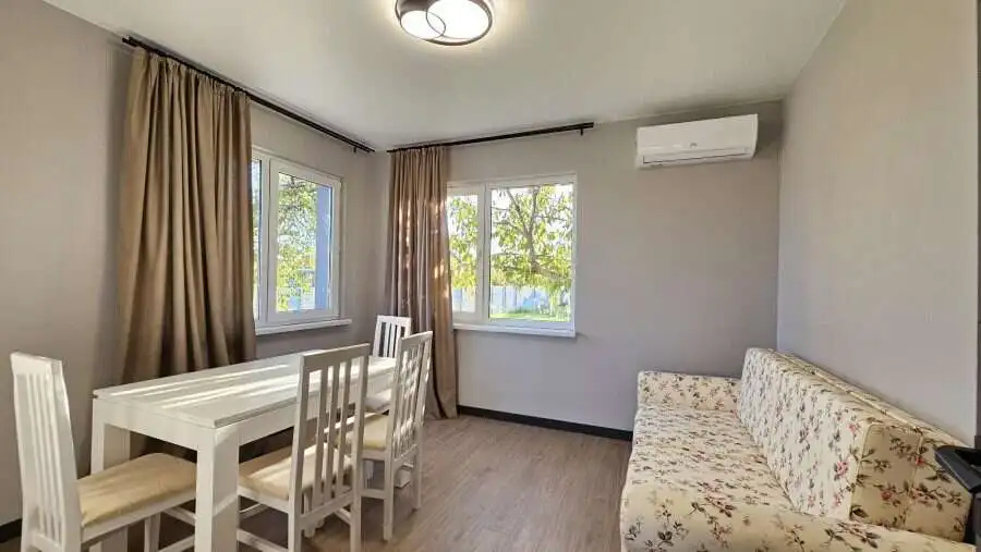 Bright interior with large windows and comfortable furnishings.