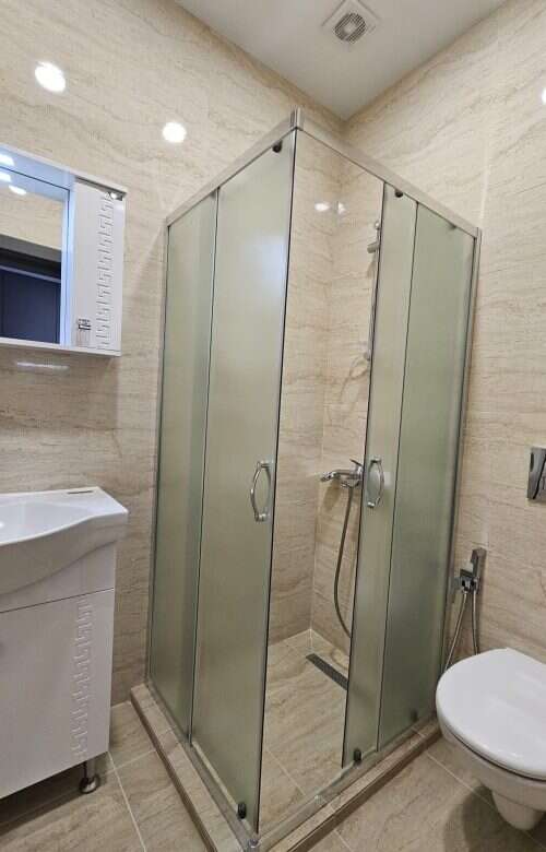 Shower enclosure with glass doors in a contemporary bathroom setting.