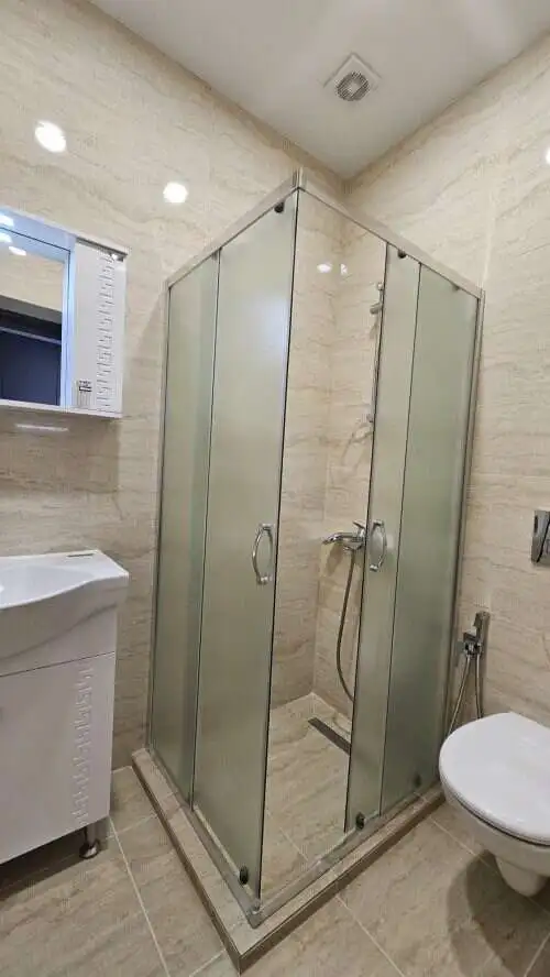 Shower enclosure with glass doors in a contemporary bathroom setting.