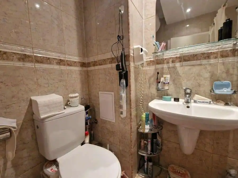 Compact bathroom with toilet and sink in a seaside studio.