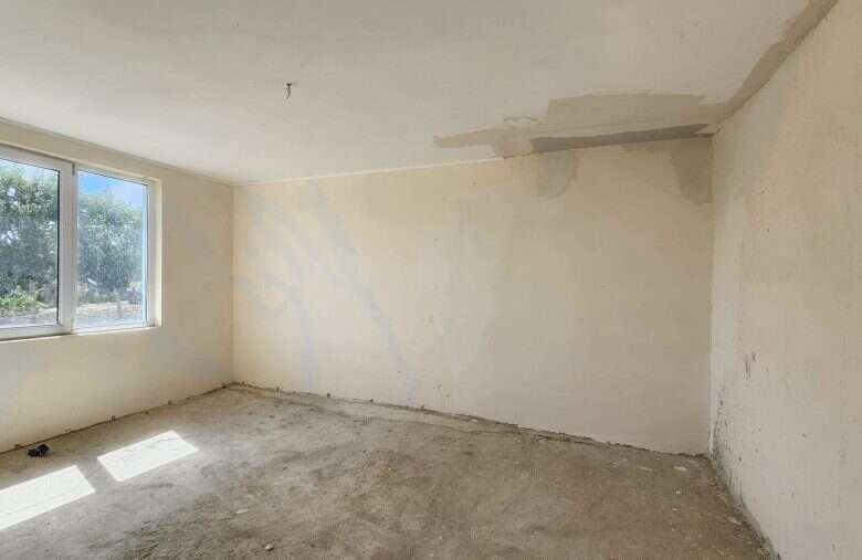Interior view of a 2-bedroom bungalow under construction in Dyulevo, Bulgaria, with large windows an.