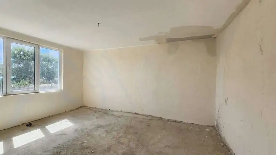 Interior view of a 2-bedroom bungalow under construction in Dyulevo, Bulgaria, with large windows an.