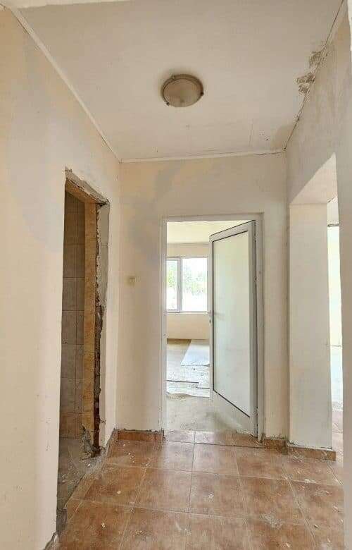 Bright interior view of a 2-bedroom bungalow in Dyulevo village, showcasing unfinished walls and ope.
