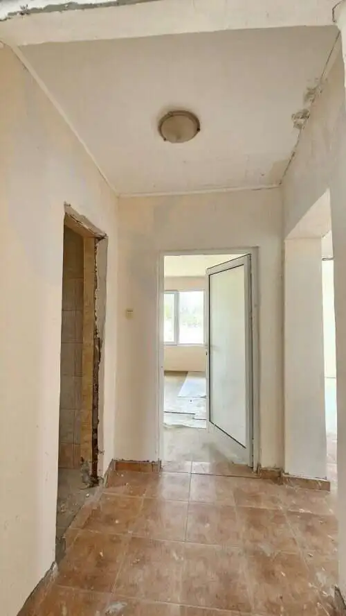 Bright interior view of a 2-bedroom bungalow in Dyulevo village, showcasing unfinished walls and ope.