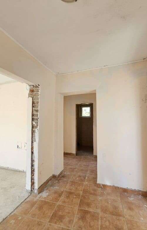 Interior view of a 2-bedroom bungalow in Dyulevo village, showcasing unfinished walls and tiled floo.
