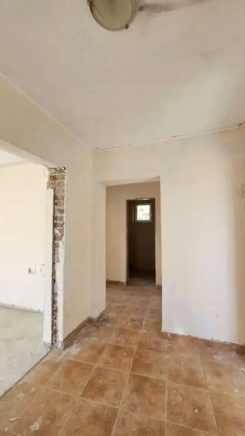 Interior view of a 2-bedroom bungalow in Dyulevo village, showcasing unfinished walls and tiled floo.