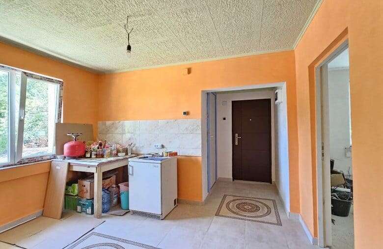 Bright interior of a renovated house with orange walls and a spacious window in Dyulevo, near Burgas.