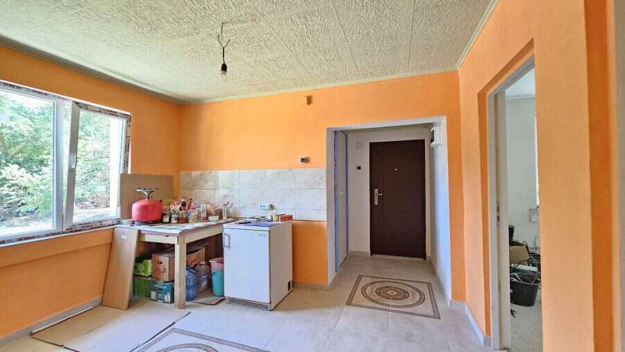 Bright interior of a renovated house with orange walls and a spacious window in Dyulevo, near Burgas.