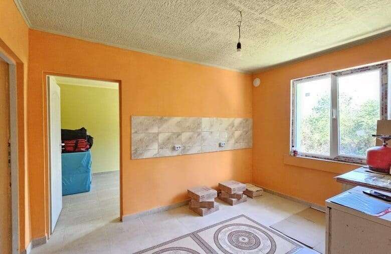 Bright interior of a renovated house with spacious room and large window in Dyulevo, Bulgaria.
