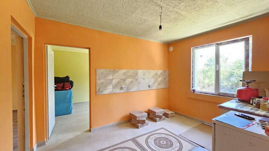 Bright interior of a renovated house with spacious room and large window in Dyulevo, Bulgaria.