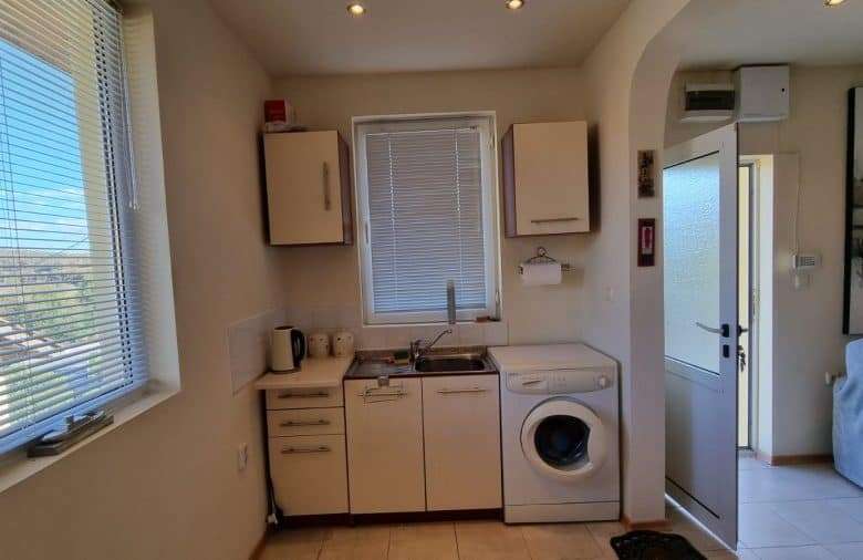 Bright kitchen with washing machine and window view.