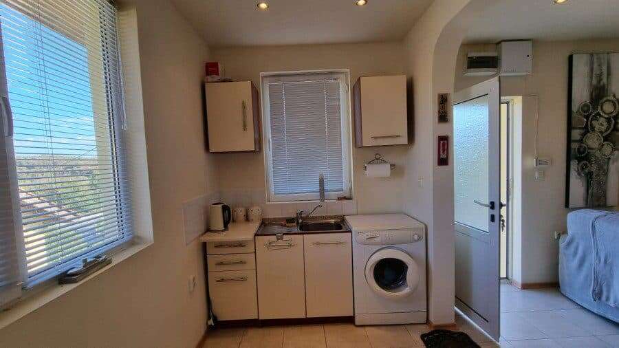 Bright kitchen with washing machine and window view.