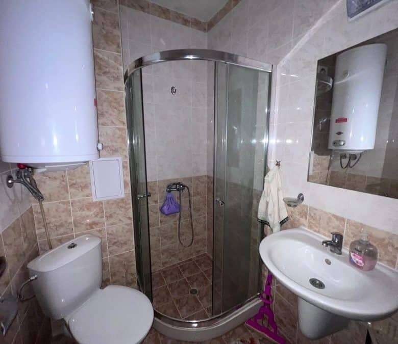 Bright bathroom with shower enclosure, toilet, and sink in Sunny Beach property.