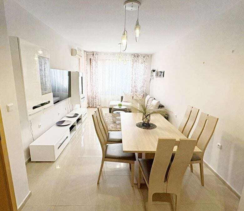 Bright living room with dining area and large windows.