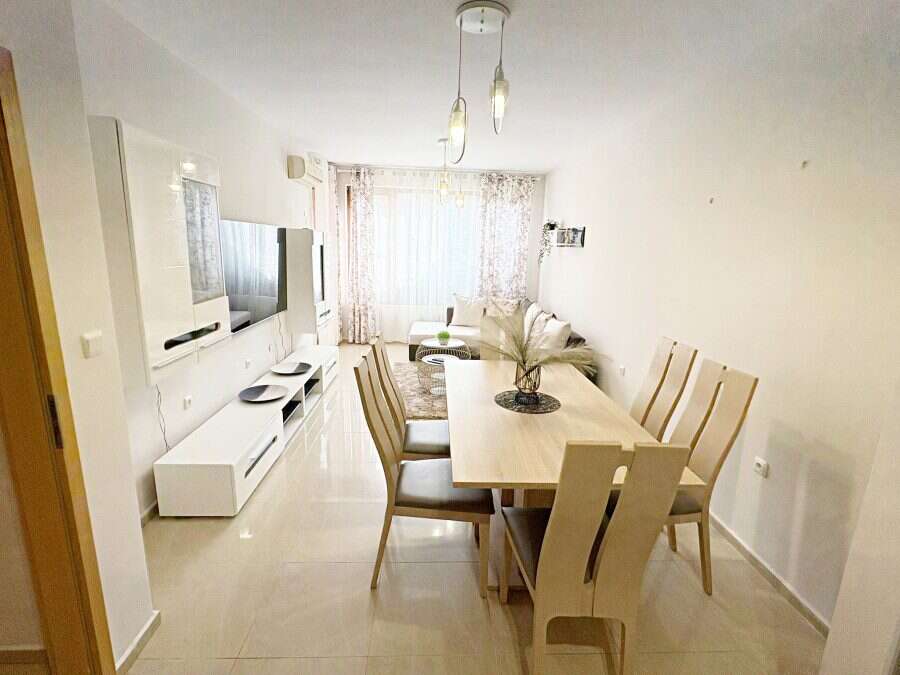 Bright living room with dining area and large windows.