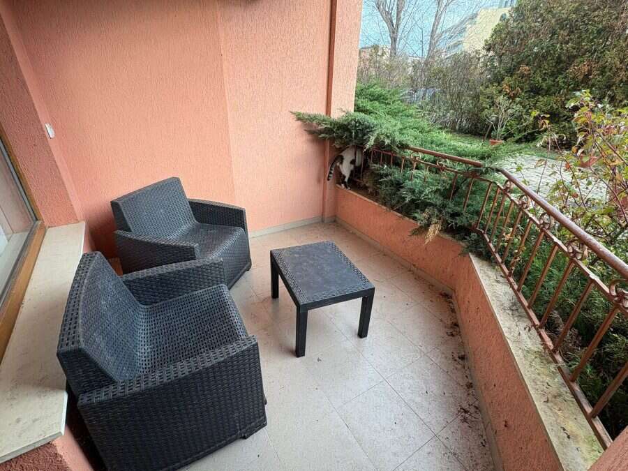 Outdoor balcony with two black wicker chairs and small table in Sunflower complex.