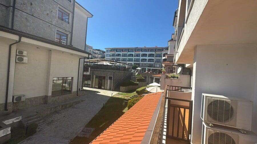 Modern apartment building exterior with balconies and air conditioning units. Bright view of a contemporary residential complex near the sea.