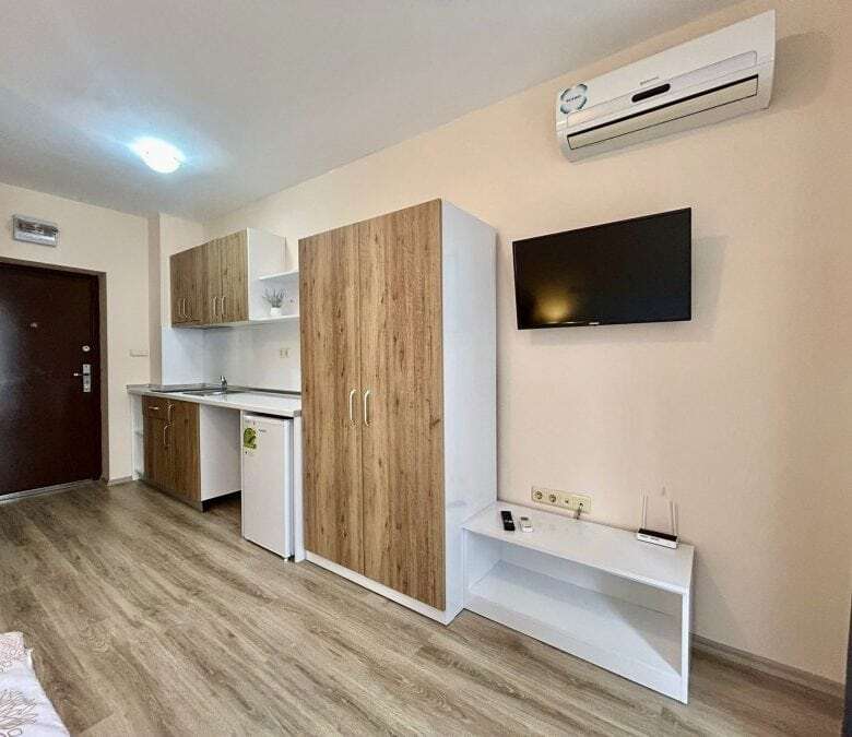 Interior of a furnished studio apartment with garden views, compact kitchen, and modern amenities in.