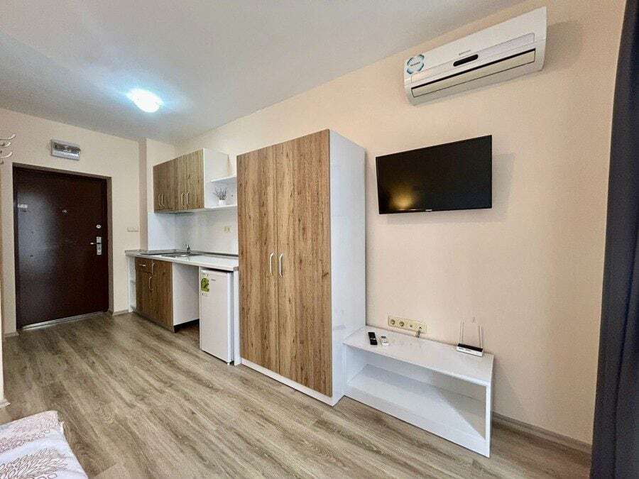 Interior of a furnished studio apartment with garden views, compact kitchen, and modern amenities in.