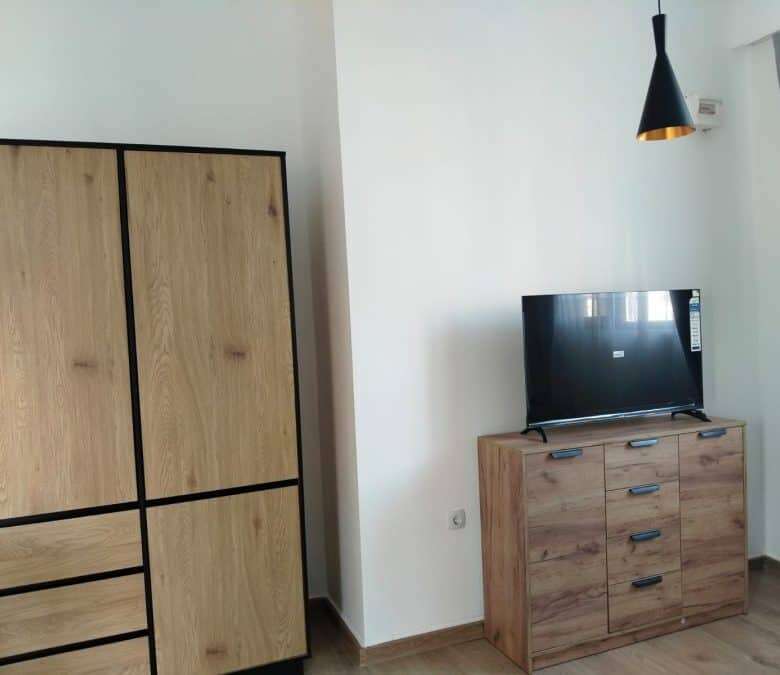 Cozy studio living space with wooden furniture and a flat-screen TV in Sunny Beach, Bulgaria.
