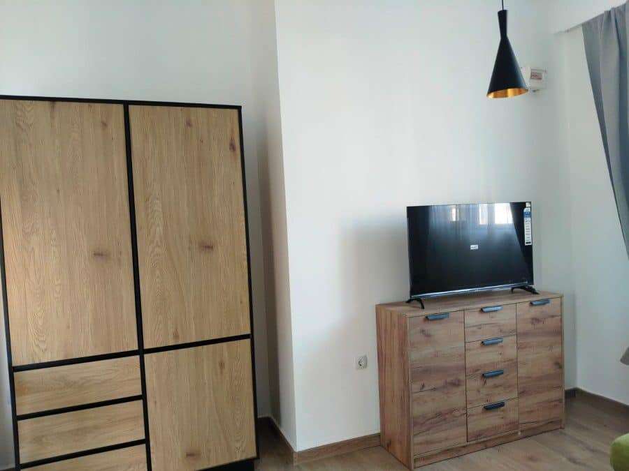 Cozy studio living space with wooden furniture and a flat-screen TV in Sunny Beach, Bulgaria.