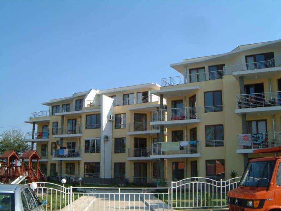 Modern seaside apartment building in Nessebar, Bulgaria. Bright, multi-story residential complex with balconies overlooking the sea.