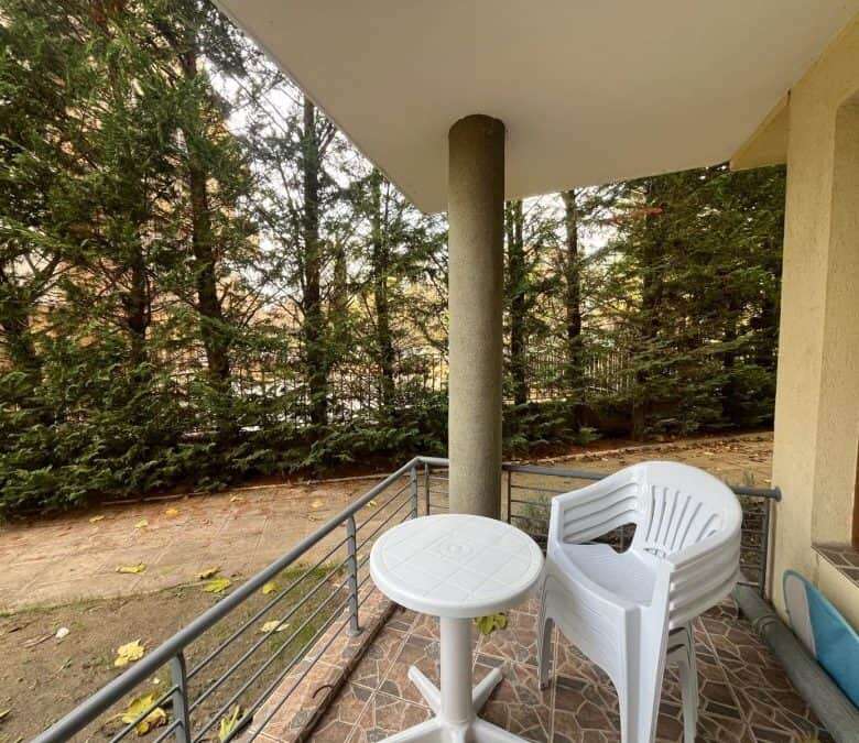 Sea view 2-bedroom apartment in Nessebar, Bulgaria, with balcony overlooking lush greenery.