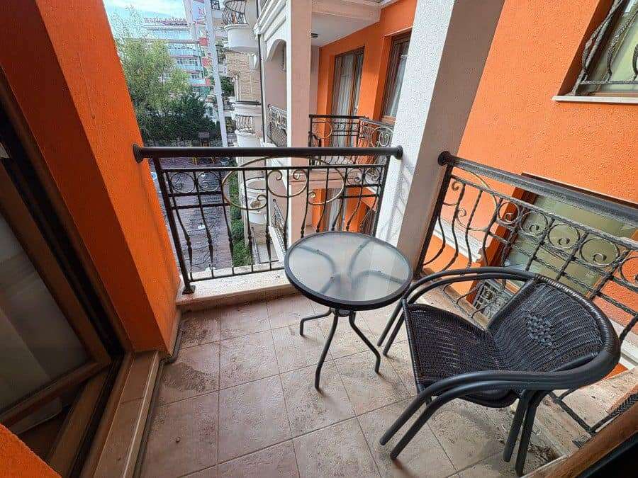 Balcony with two chairs and small round table overlooking the vibrant Sunny Beach area.