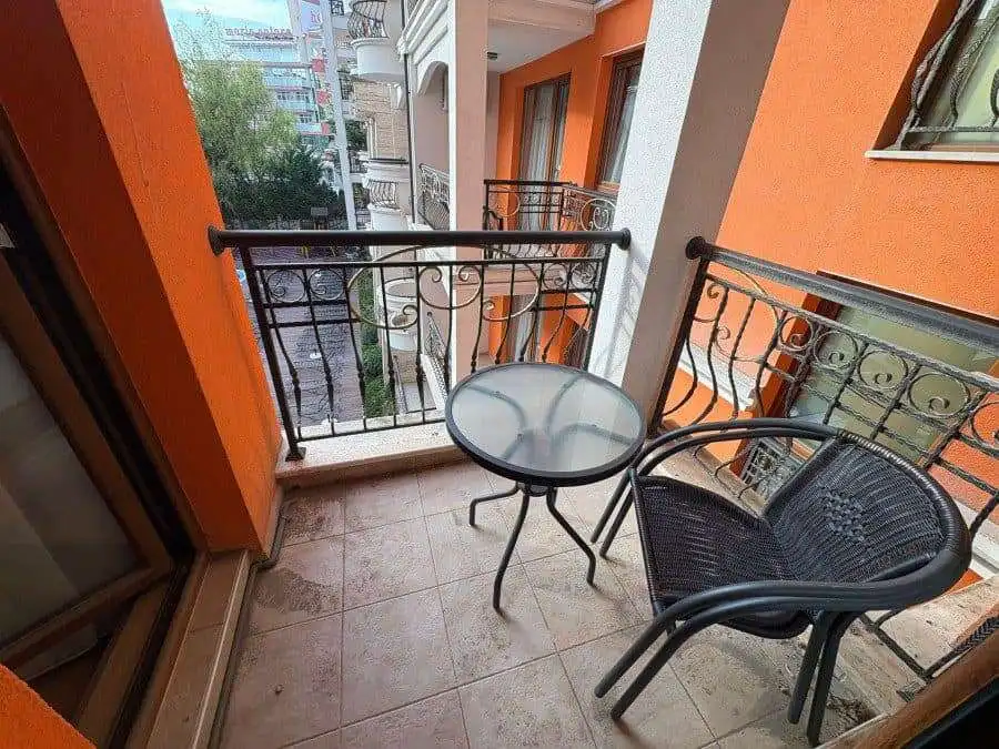 Balcony with two chairs and small round table overlooking the vibrant Sunny Beach area.