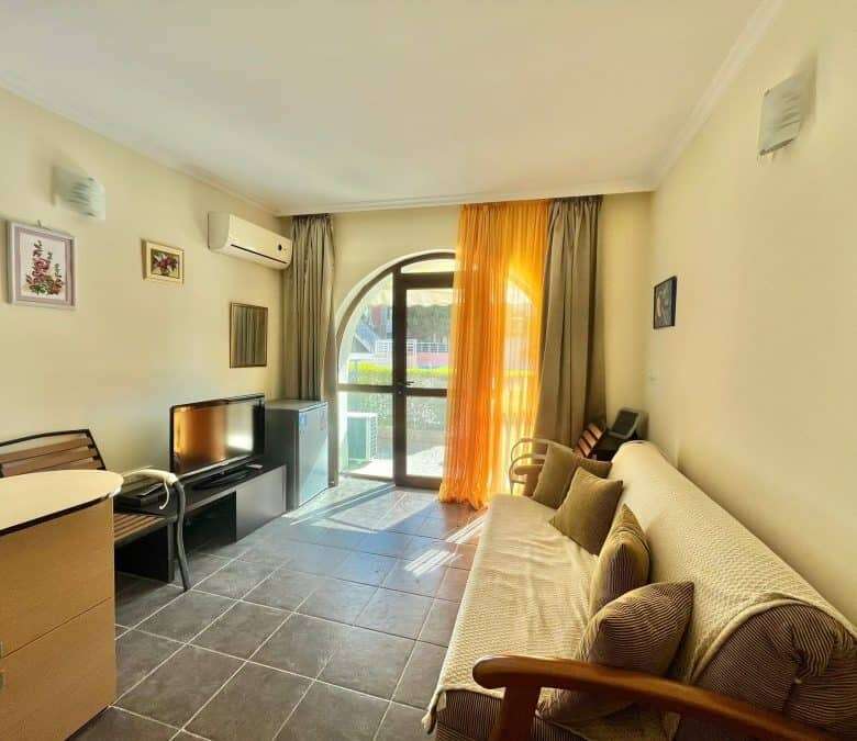 Bright interior with balcony and comfortable furnishings.