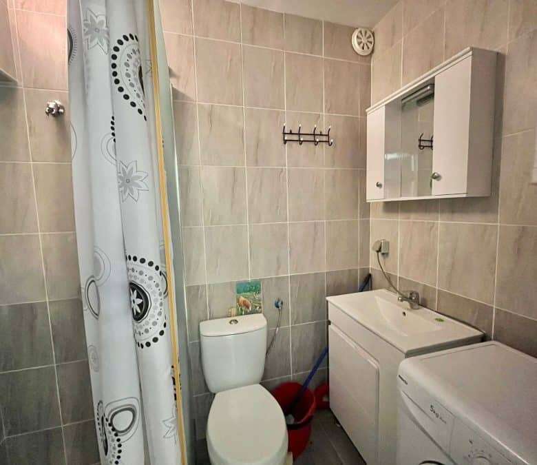 Bright bathroom with toilet, sink, and washing machine in Sveti Vlas.