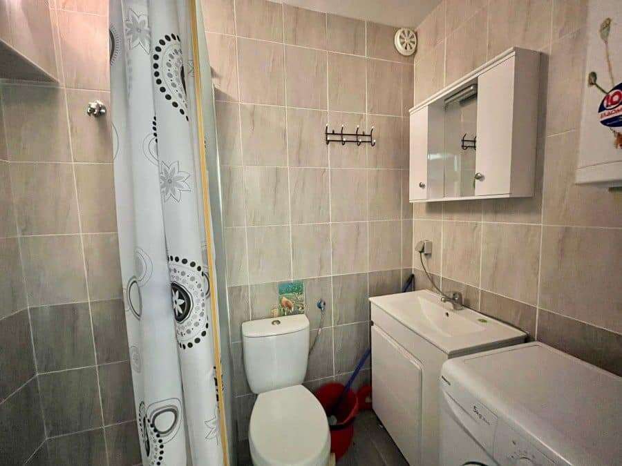Bright bathroom with toilet, sink, and washing machine in Sveti Vlas.