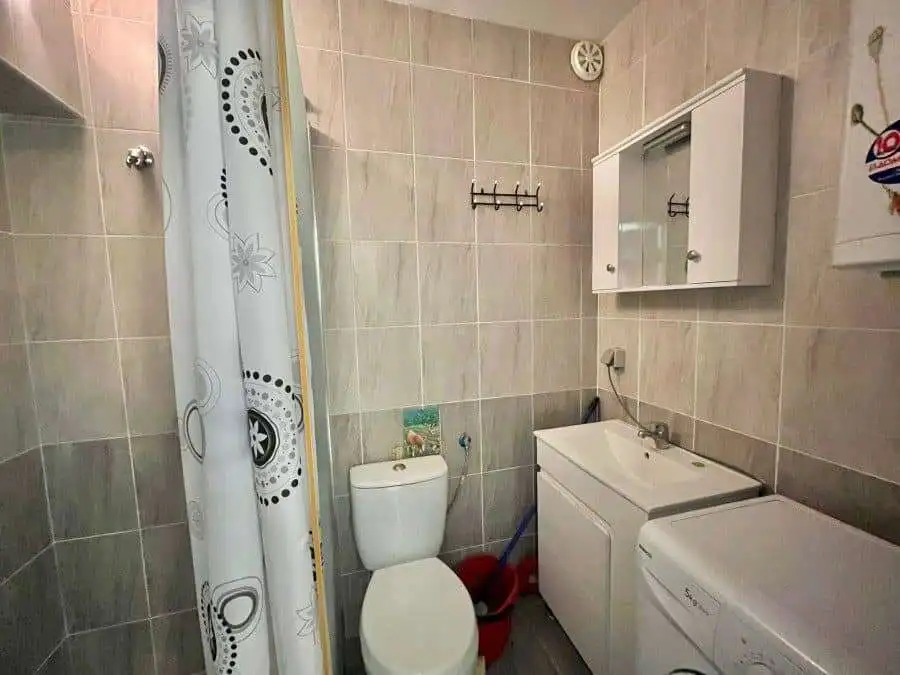 Bright bathroom with toilet, sink, and washing machine in Sveti Vlas.