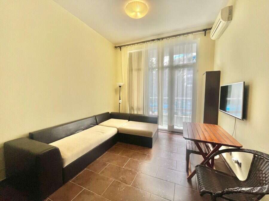 Modern studio with pool view in Nessebar, 38 sq.m. Bright living area with sofa and large window.